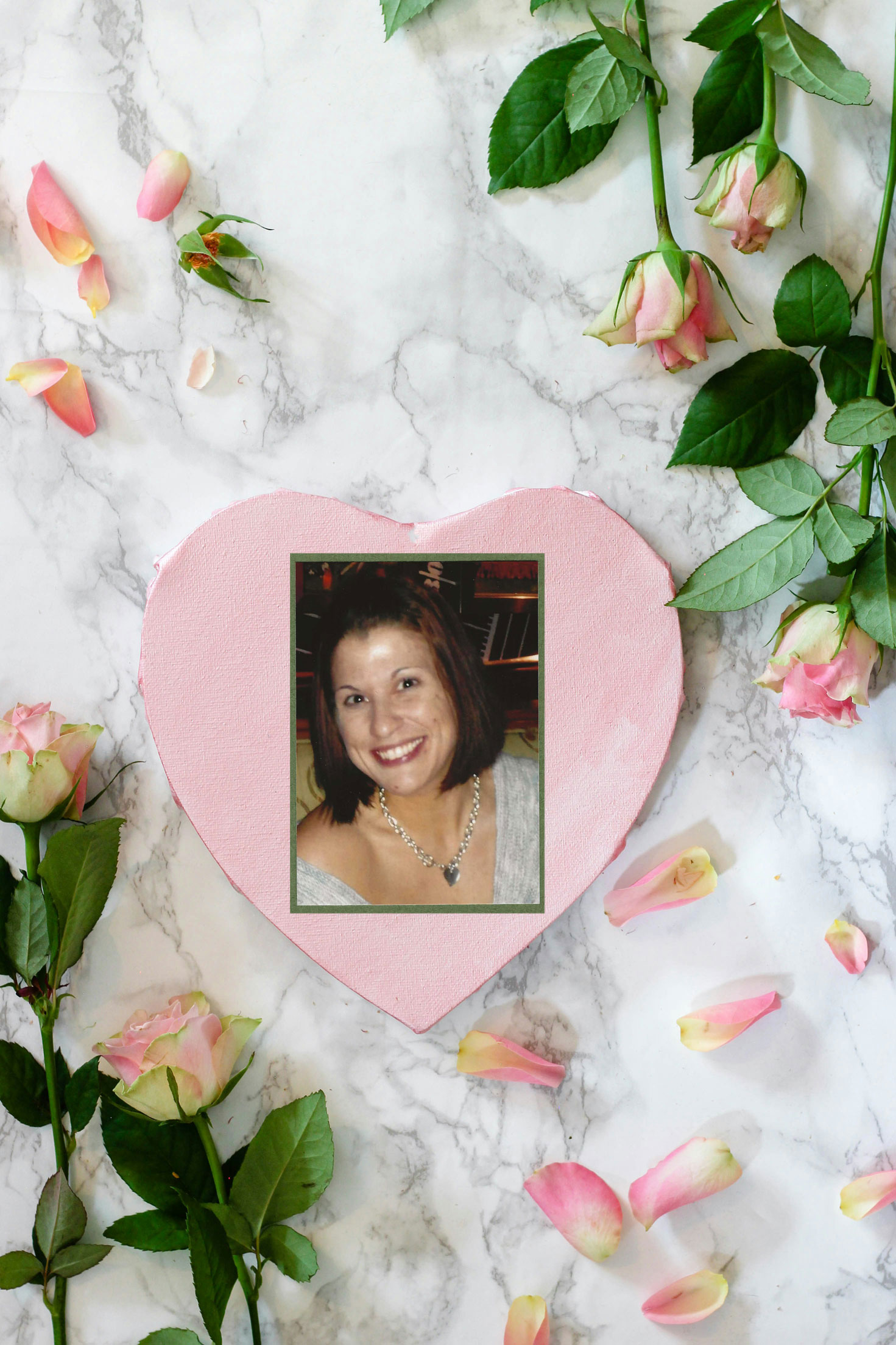 Pink heart shaped paper on white and pink floral textile with photo of elizabeth rose wilson